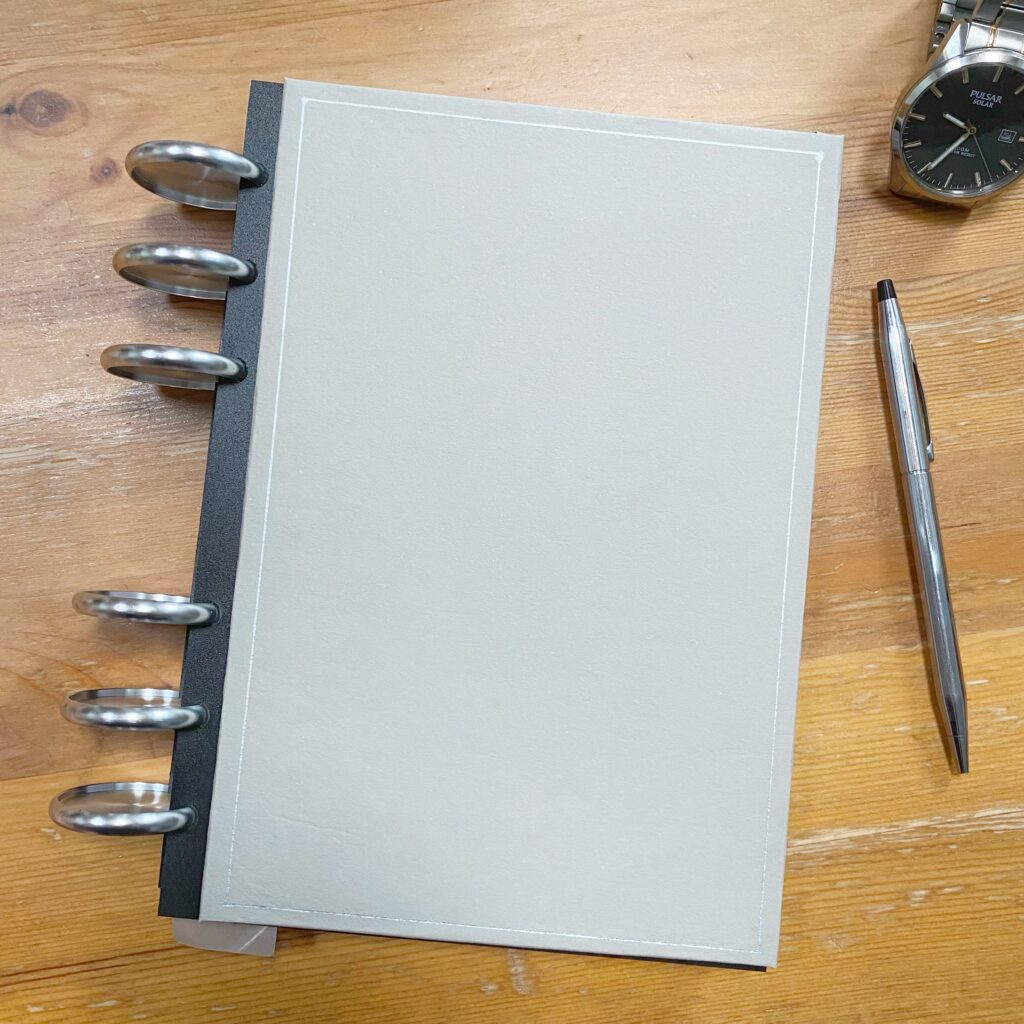 Picture of a discbound planner showing a very simple design for a planner cover. Part of an article - 5 planner design hacks to make your planner beautiful.