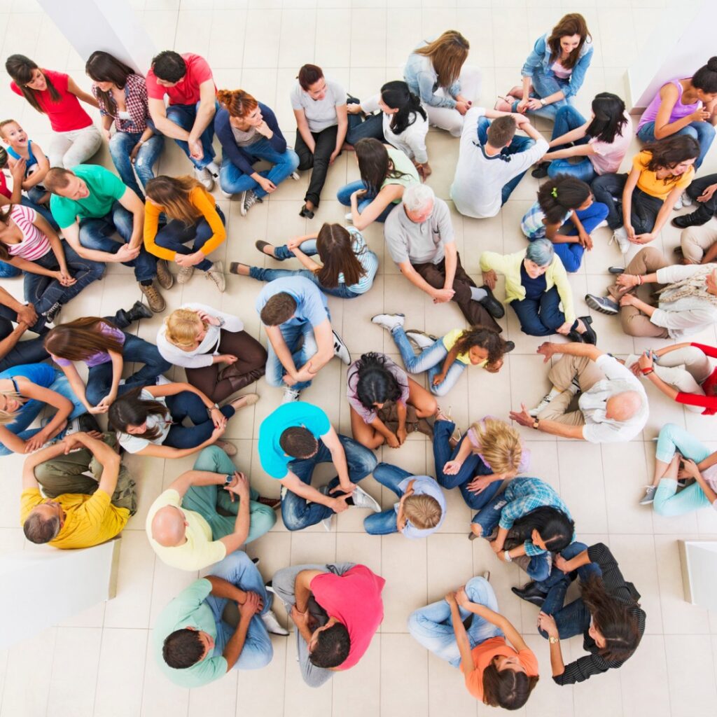 Picture of a large group of people sitting on the floor. Part of an article: bullet journal ireland - everything you need to know