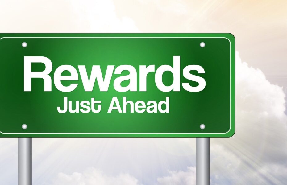 Picture of a sign post among clouds that says - rewards just ahead. Part of an article - create a personal reward system to help you achieve your goals
