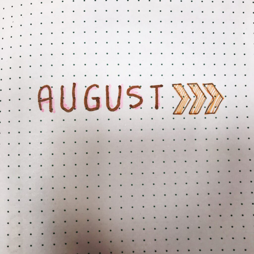 A picture of a bullet journal page with the word August on it and 3 arrows to the side. Part of an article: 5 Effortless Bullet Journal Monthly Spread Ideas for Beginners